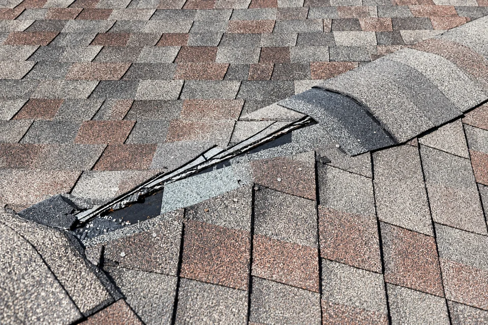 AI-anonymized illustration of missing roof covering along a shingled roof junction